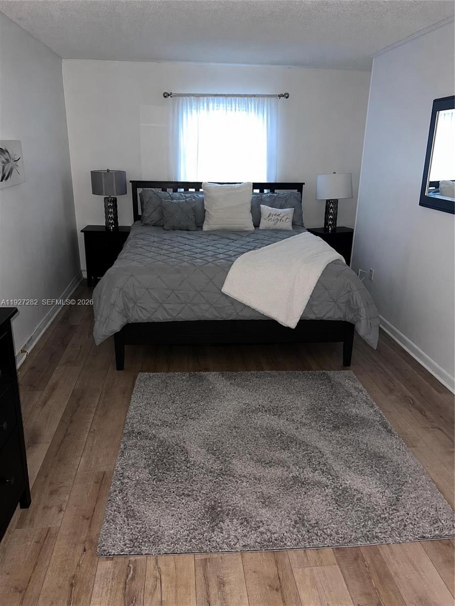 A bedroom features a bed with grey bedding, two nightstands, and a grey area rug — 4740 NW 21st St # 4P, Lauderhill FL 33313, LAUDERHILL, FL