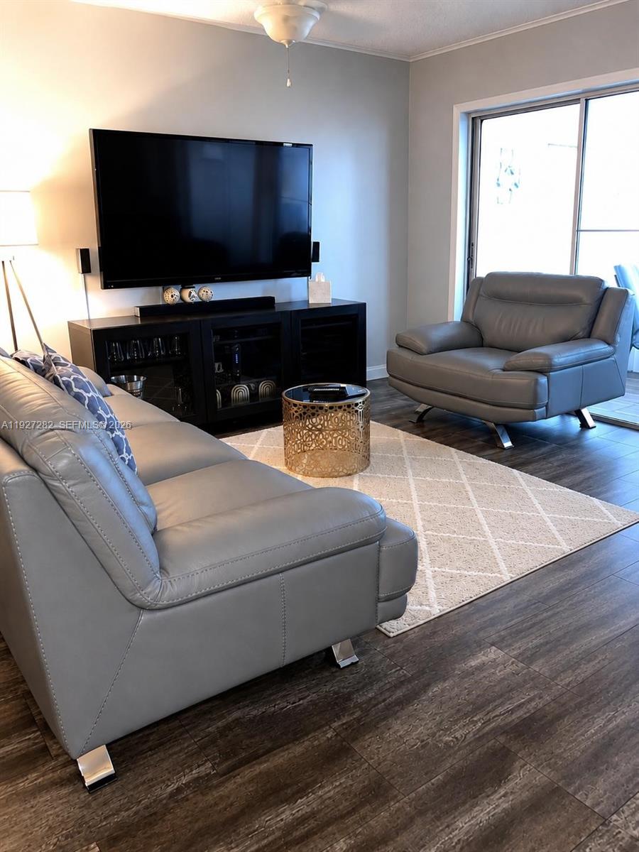 A living room features gray leather furniture, a gold drum table, and dark wood flooring — 4740 NW 21st St # 4P, Lauderhill FL 33313, LAUDERHILL, FL