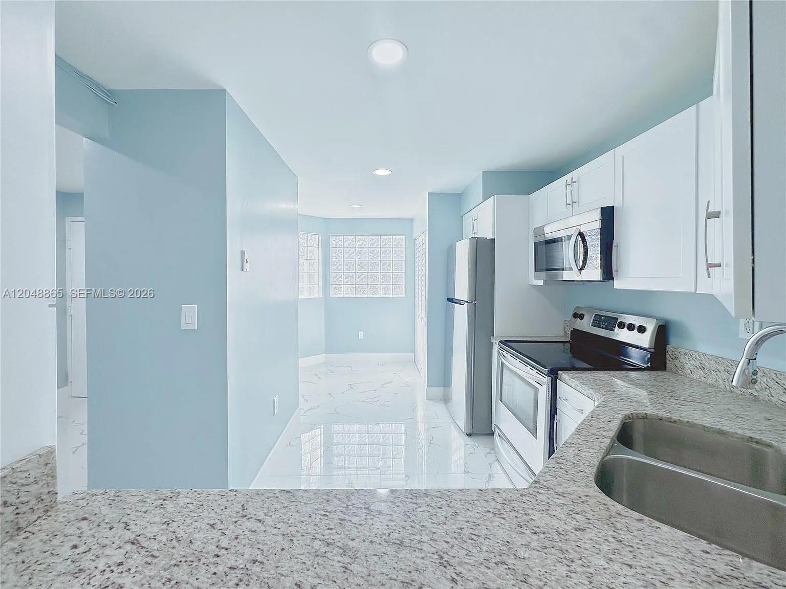 A kitchen with white cabinets, granite countertops, and a stainless steel refrigerator and stove — 10014 Hammocks Blvd # 4, Miami FL 33196, MIAMI, FL