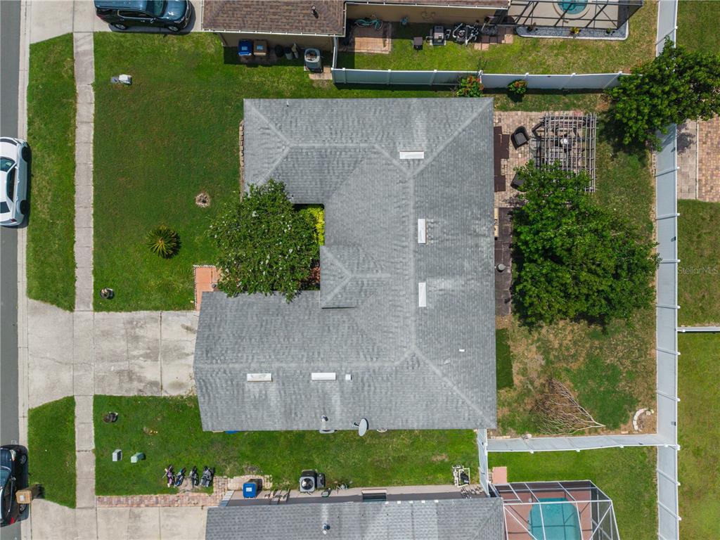 An aerial view shows a single-story house with a gray shingled roof and surrounding yard — 5121 HEATHERSTONE COURT, KISSIMMEE, FL