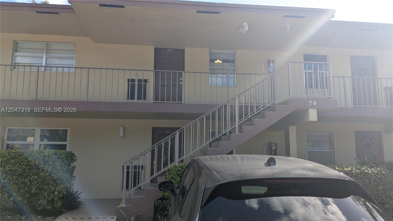 A two-story apartment building exterior features a metal staircase leading to an upper balcony — 481 NW 76th Ave # 207, Margate FL 33063, MARGATE, FL