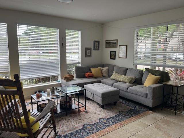 A living room features a gray sectional sofa, a patterned rug, and a wooden rocking chair — 1000 Crystal Way # A, Delray Beach FL 33444, DELRAY BEACH, FL