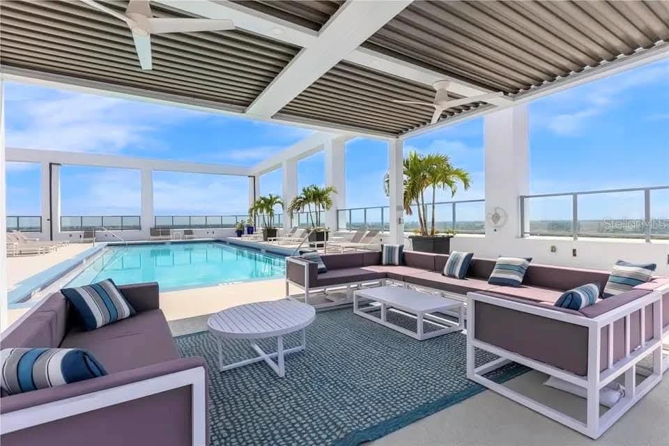 An outdoor lounge area features a swimming pool, modern furniture, and a covered patio ceiling — 260 S OSCEOLA AVENUE UNIT 709, ORLANDO, FL