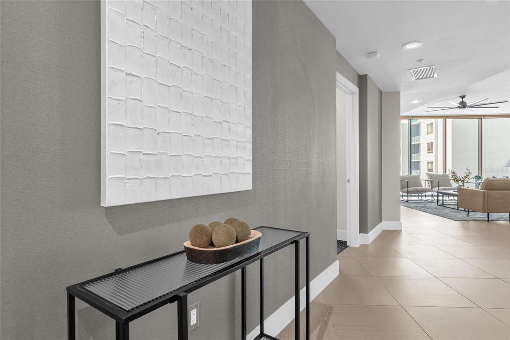 A hallway with a textured white wall art piece above a black console table — 260 S OSCEOLA AVENUE UNIT 709, ORLANDO, FL
