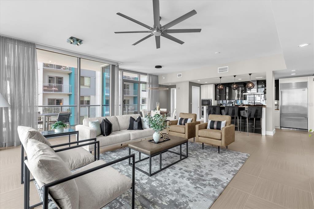 A modern open-concept living room features a neutral sofa, armchairs, and a kitchen with barstools — 260 S OSCEOLA AVENUE UNIT 709, ORLANDO, FL