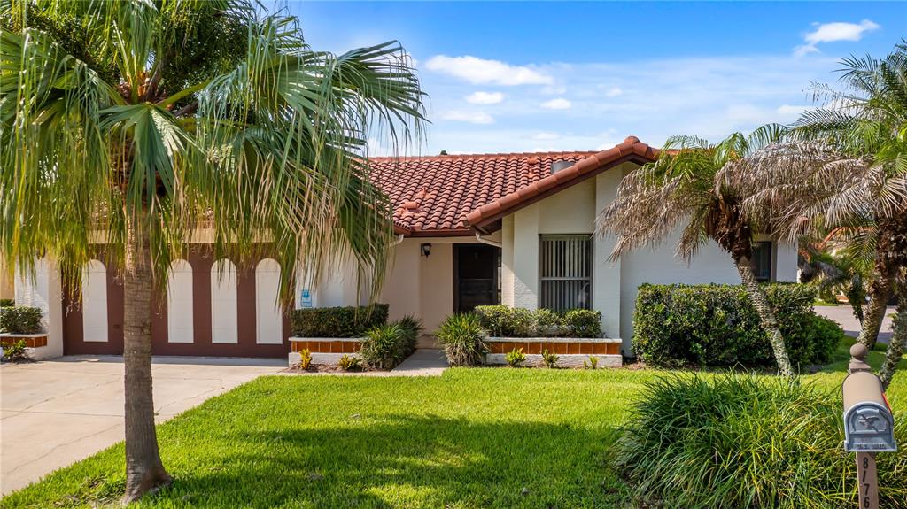 A single-story house with a tiled roof, garage, and palm trees in the front yard — 8176 TERRAZA COURT, ORLANDO, FL