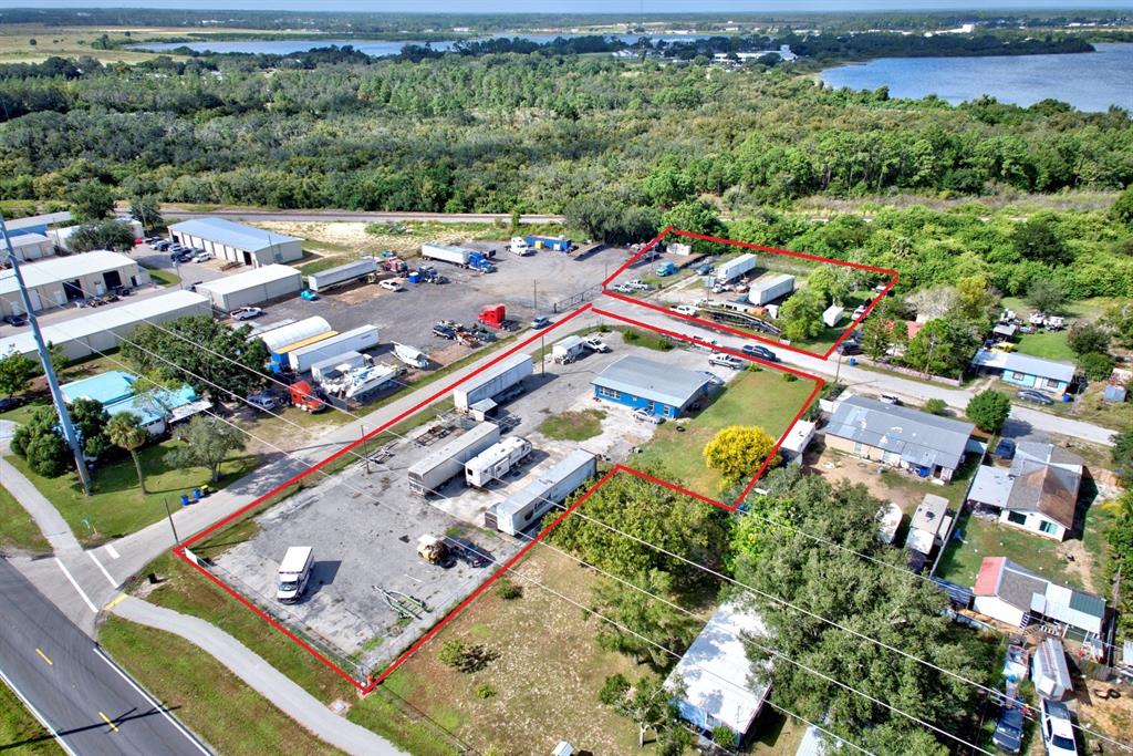 An aerial view shows a commercial property with multiple storage trailers and a blue building — 1087 MEMORIAL DRIVE, AVON PARK, FL