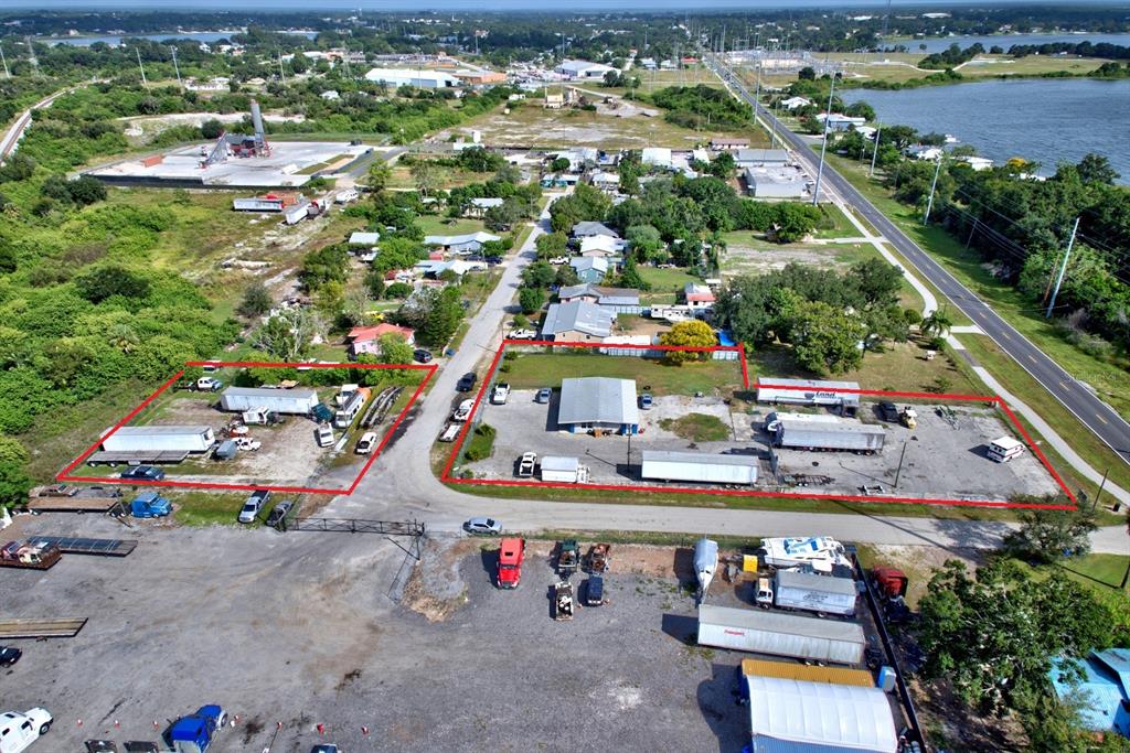 Aerial view of two commercial lots with storage trailers and a warehouse building — 1087 MEMORIAL DRIVE, AVON PARK, FL