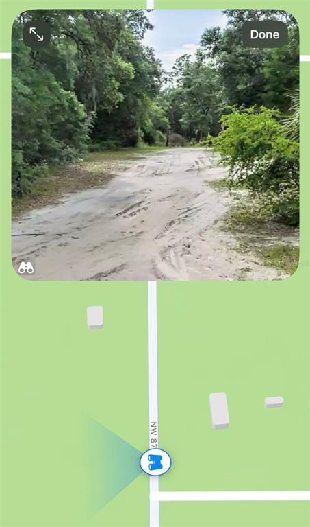 This is a map view showing a street-level photo of a sandy, wooded dirt road — 128TH PLACE, CHIEFLAND, FL