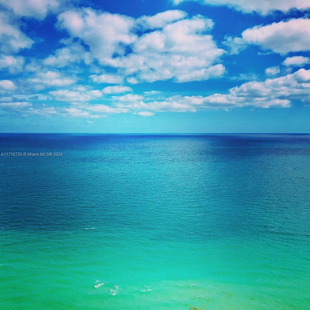 A high-angle view of the turquoise ocean meeting a blue sky with scattered clouds — 1850 S Ocean Dr # 3310, Hallandale Beach FL 33009, HALLANDALE BEACH, FL