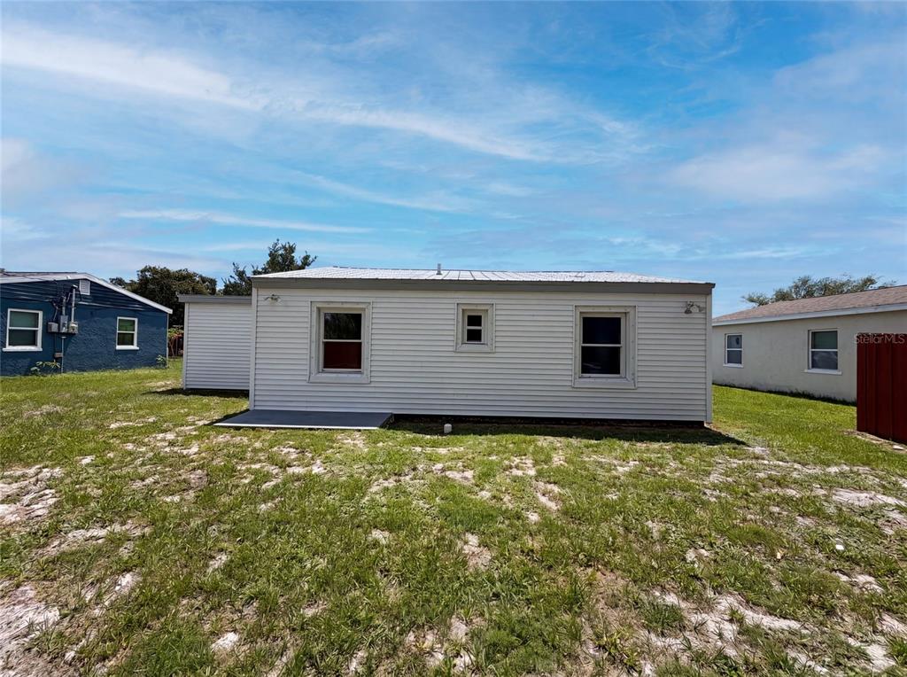 The exterior of a single-story house with white horizontal siding and a metal roof — 1604 PARK AVENUE, MELBOURNE, FL