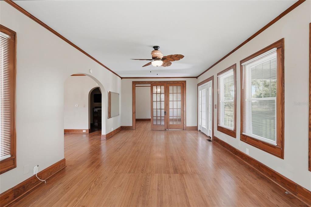 An empty room with hardwood floors, crown molding, a ceiling fan, and French doors — 4227 2ND AVENUE N, ST PETERSBURG, FL