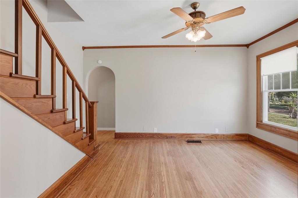 A room with hardwood floors, a wooden staircase, an arched doorway, and a ceiling fan — 4227 2ND AVENUE N, ST PETERSBURG, FL