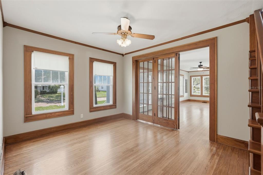 A room with hardwood floors, wood trim, French doors, and two windows looking outside — 4227 2ND AVENUE N, ST PETERSBURG, FL