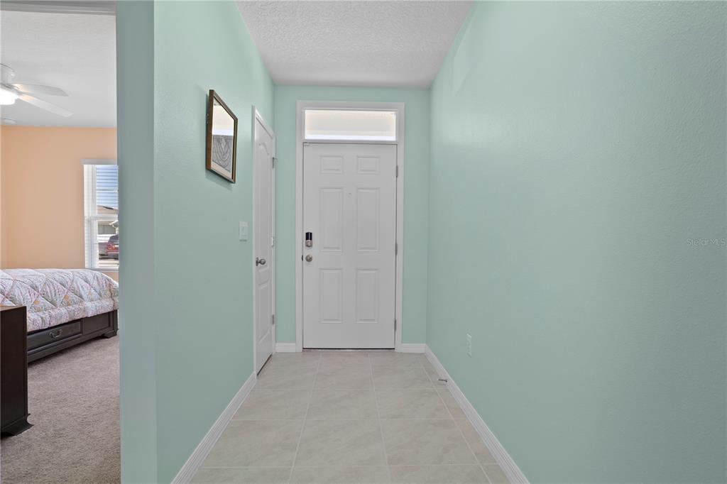 A light-colored entryway features tile flooring, pale green walls, and a white front door — 2648 NEVERLAND DRIVE, NEW SMYRNA BEACH, FL