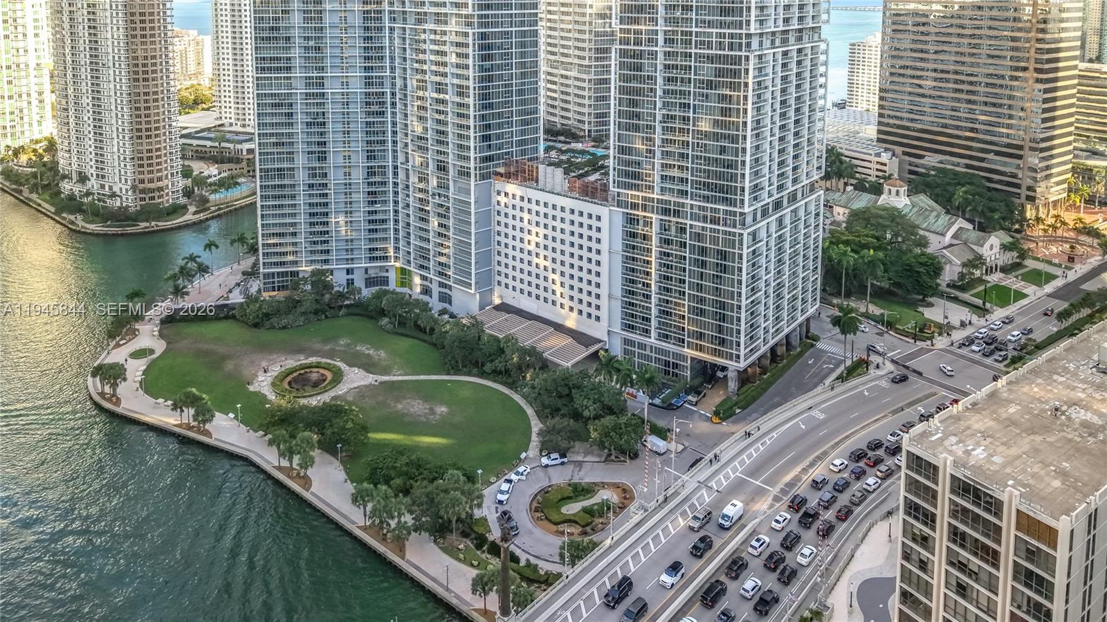 An aerial view shows high-rise buildings, a waterfront park, and a busy multi-lane road — 475 Brickell Ave # 4215, Miami FL 33131, MIAMI, FL