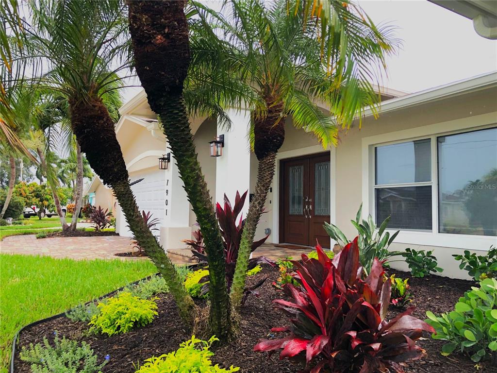 A swimming pool overlooks a canal with a boat lift and palm trees — 7901 10TH AVENUE S, ST PETERSBURG, FL