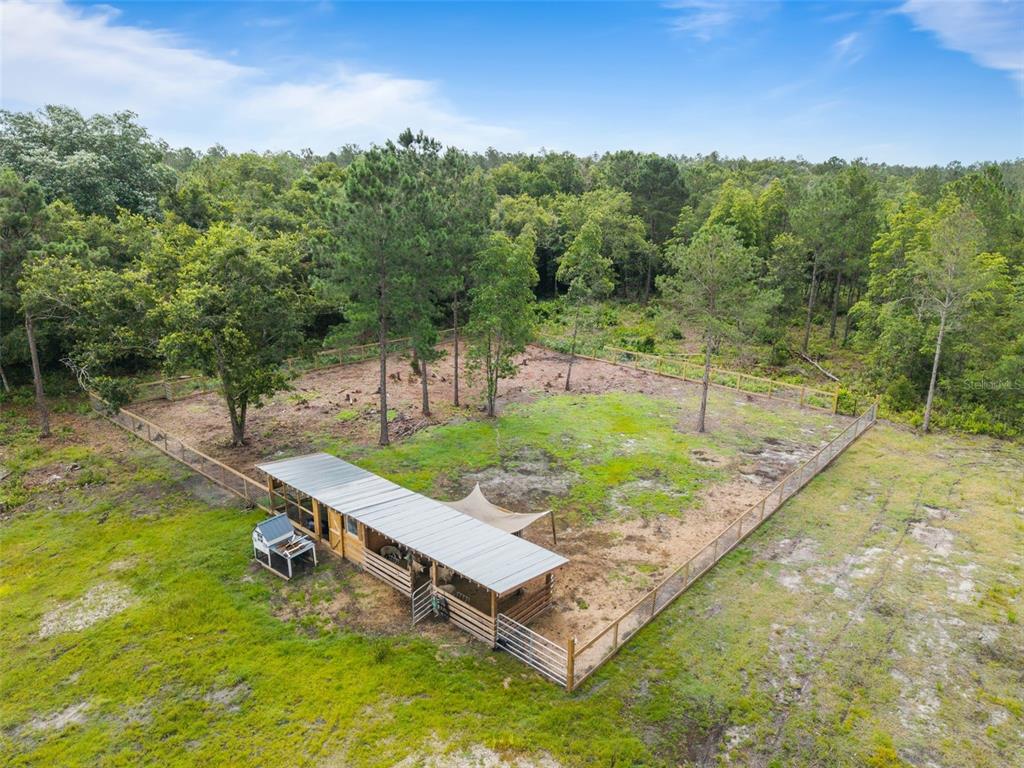 An aerial view shows a fenced animal enclosure with a covered shelter and trees — TBD RETREAT ROAD, KEYSTONE HEIGHTS, FL