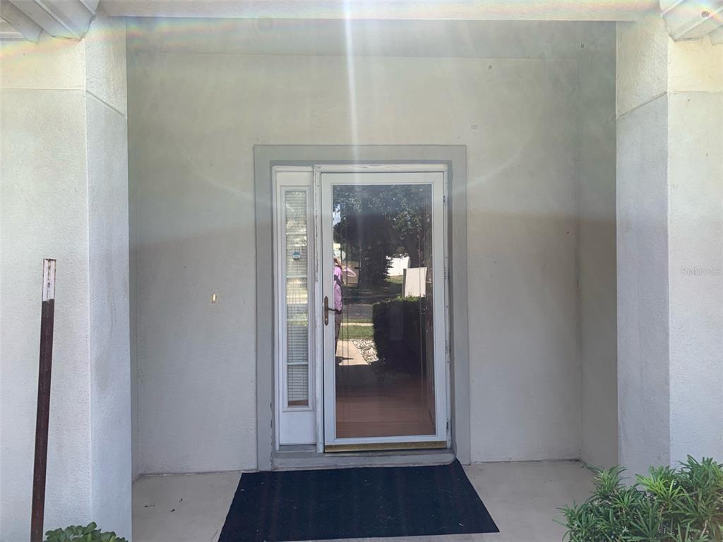 A front entryway features a white door with a glass storm door and sidelight — 4311 SW 53RD TERRACE, OCALA, FL
