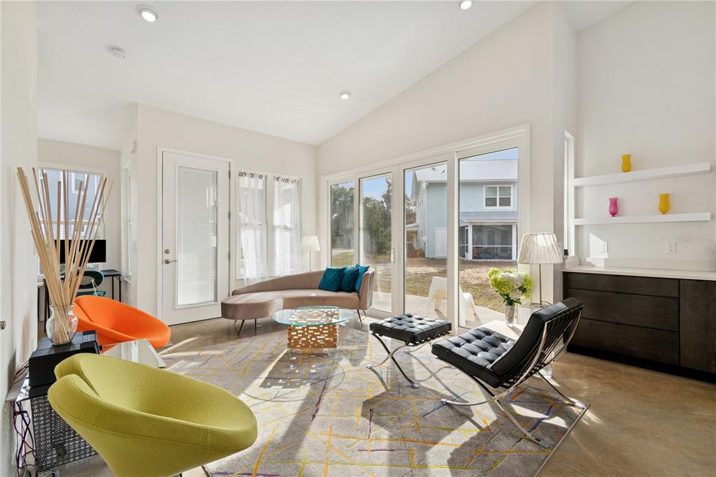 A bright living room features modern furniture, a patterned rug, and large sliding glass doors — 2668 NW 47TH TERRACE, GAINESVILLE, FL