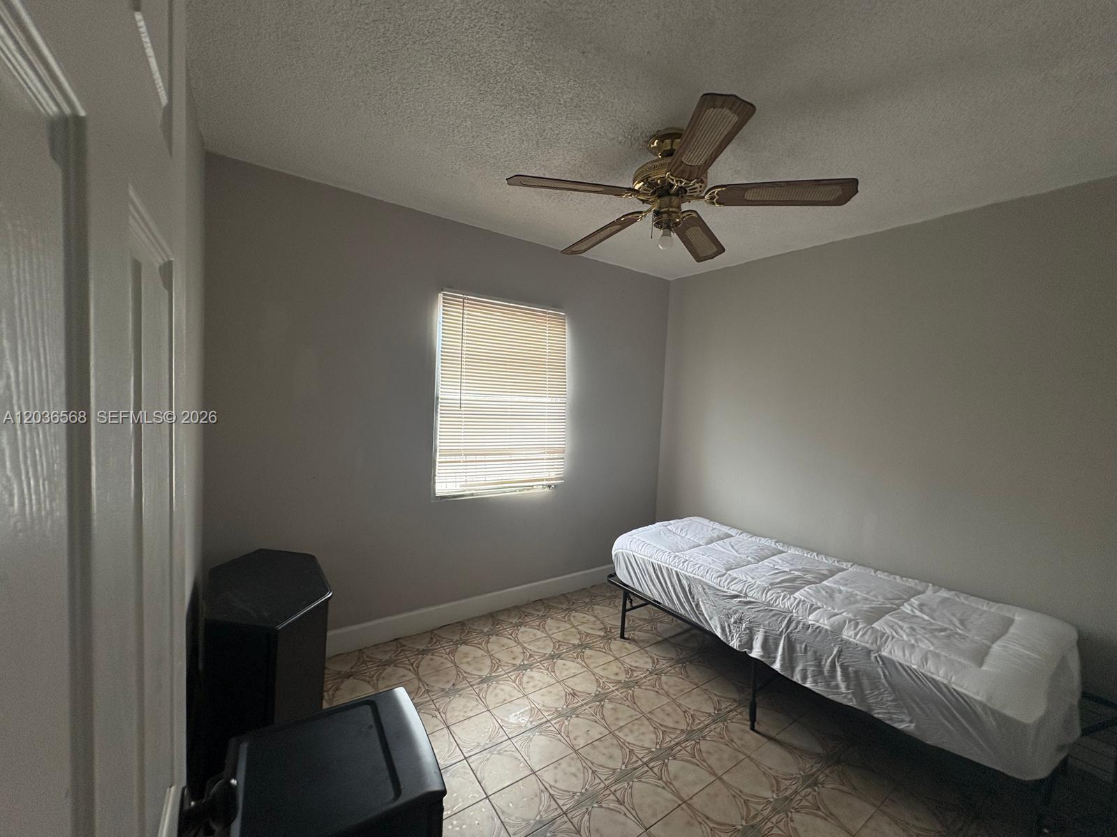 A bedroom features a single bed, a ceiling fan, and tiled flooring — 610 NE 4th Pl # 1, Hialeah FL 33010, HIALEAH, FL