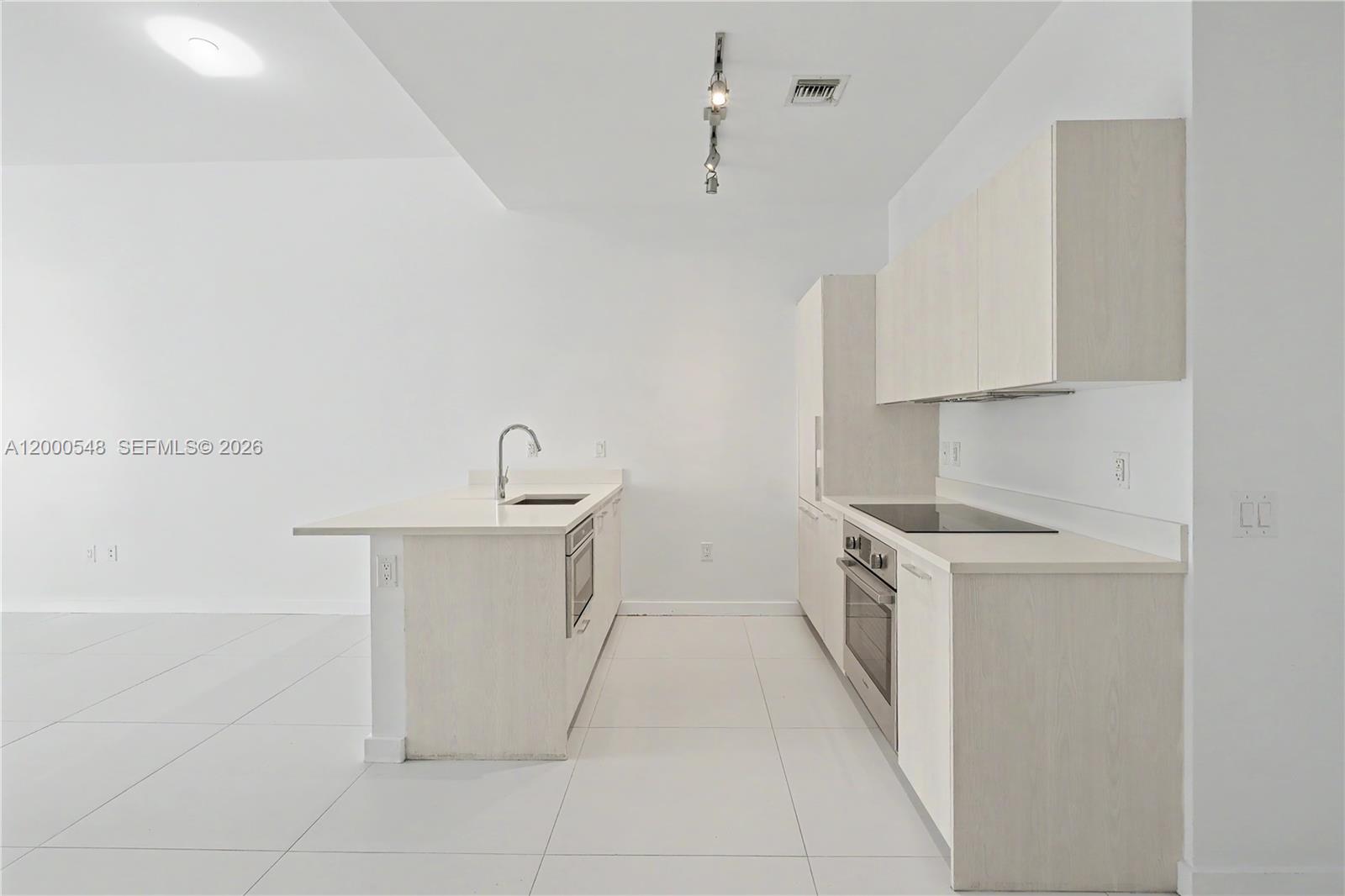 A small, minimalist bathroom features a white toilet, a pedestal sink, and chrome fixtures — 501 NE 31st St # 302, Miami FL 33137, MIAMI, FL