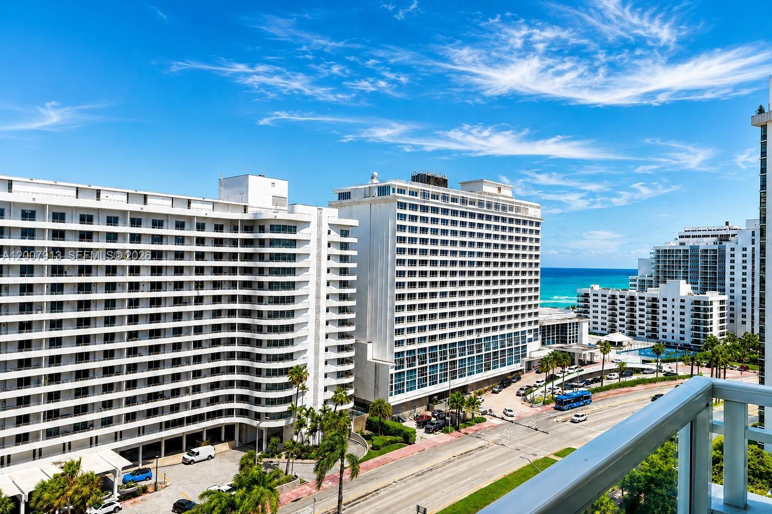 An elevated view of several large white apartment buildings near the ocean and a road — 5600 Collins Ave # 15B, Miami Beach FL 33140, MIAMI BEACH, FL