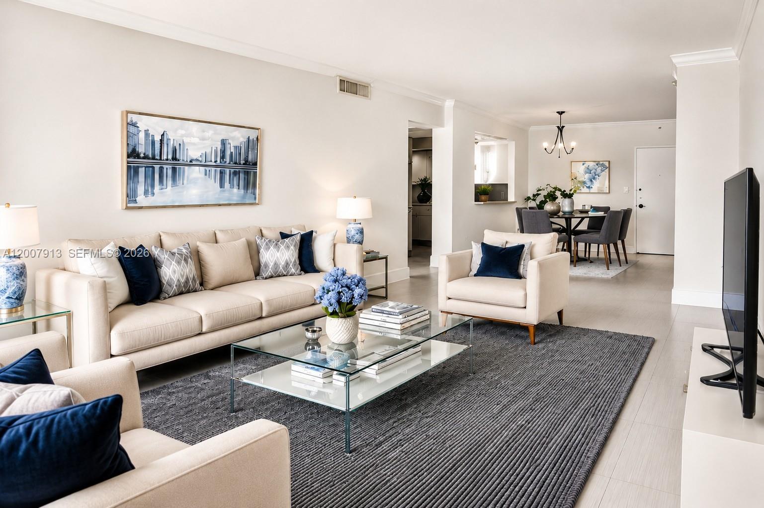 A bright living room features a beige sofa, armchairs, a glass coffee table, and dining area — 5600 Collins Ave # 15B, Miami Beach FL 33140, MIAMI BEACH, FL