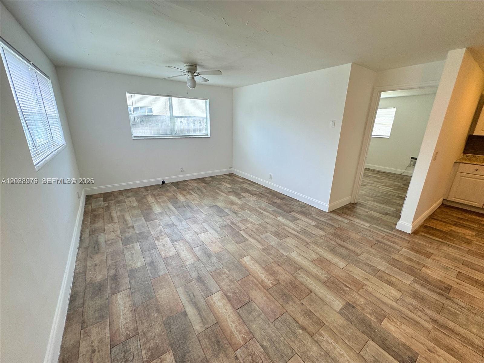 An empty room features white walls, a ceiling fan, and wood-look tile flooring — 207 SE 4th Ave, Boynton Beach FL 33435, BOYNTON BEACH, FL