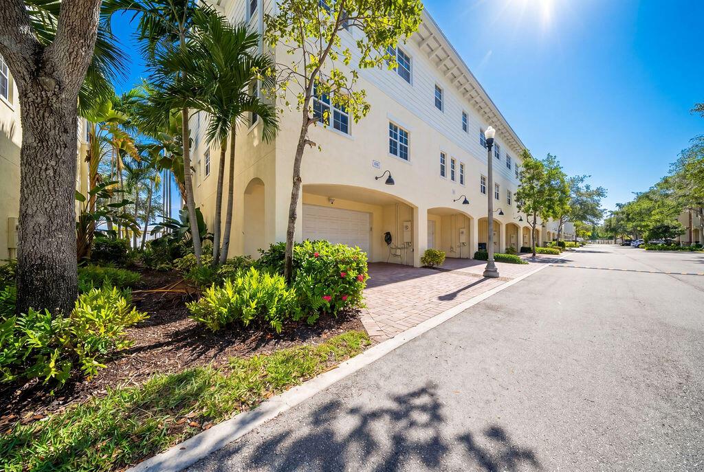 A multi-story yellow building features ground-level garage bays and a paved driveway with palm trees — 261 SW 6th Place, Pompano Beach FL 33060, POMPANO BEACH, FL