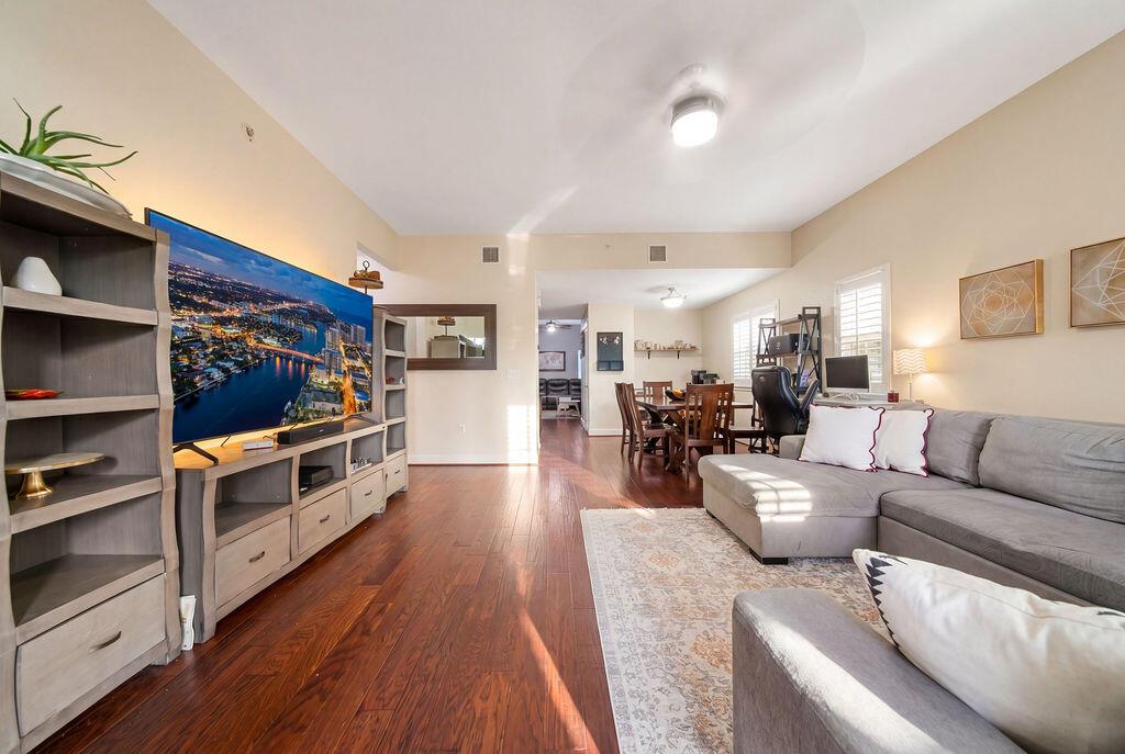 A living room with hardwood floors, a large sectional sofa, and a television media console — 261 SW 6th Place, Pompano Beach FL 33060, POMPANO BEACH, FL