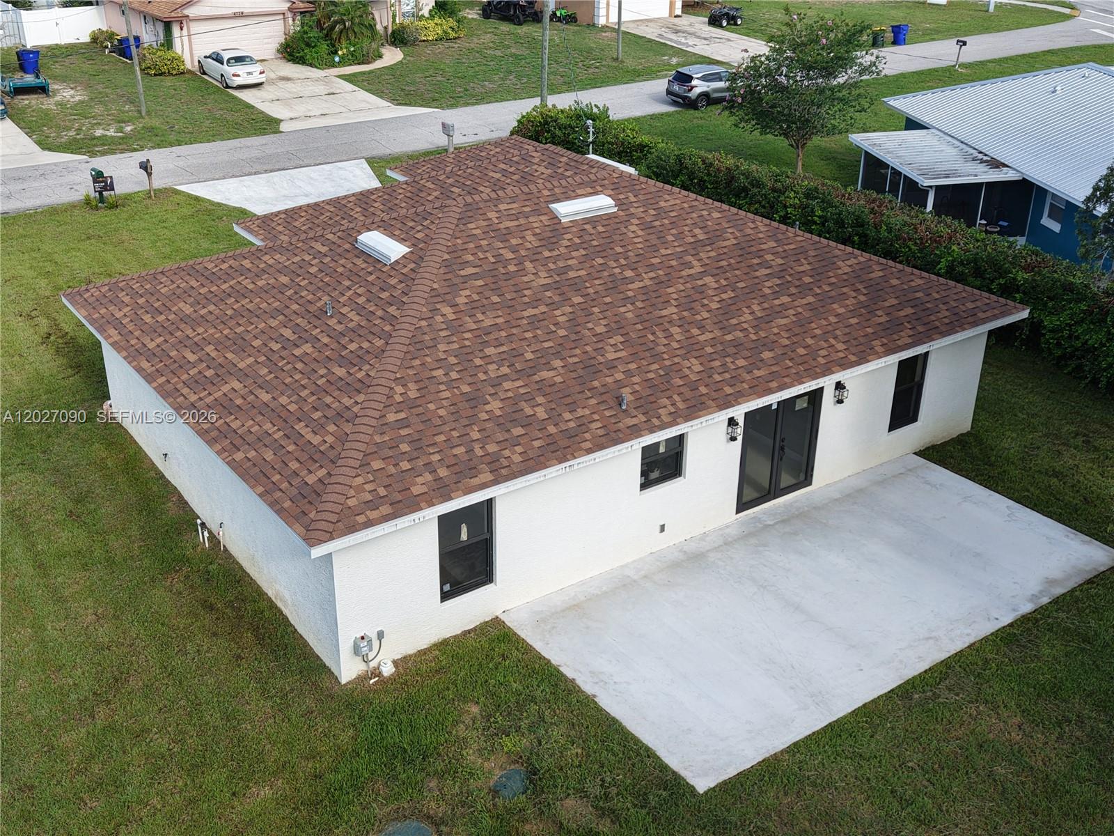 An aerial view of a white house with a brown shingled roof and concrete patio — 4726 Trout Ave, Sebring FL 33870, SEBRING, FL