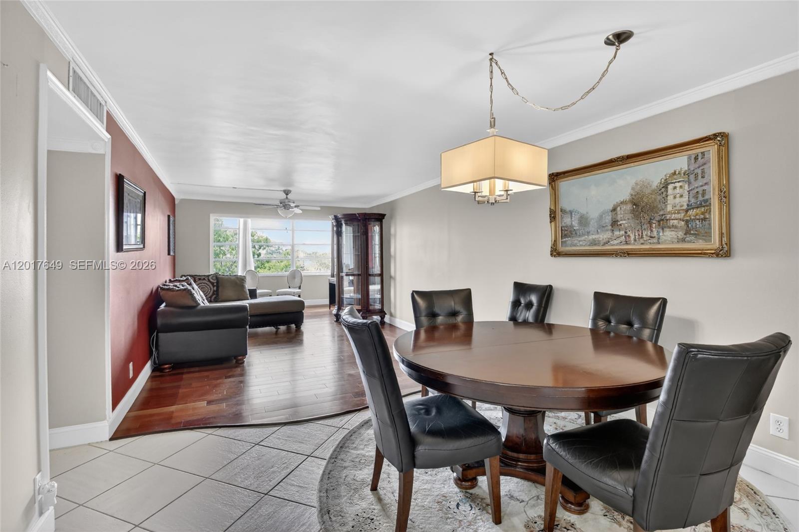 A dining area with a round table and leather chairs transitions into a living room — 6600 Cypress Rd # 504, Plantation FL 33317, PLANTATION, FL