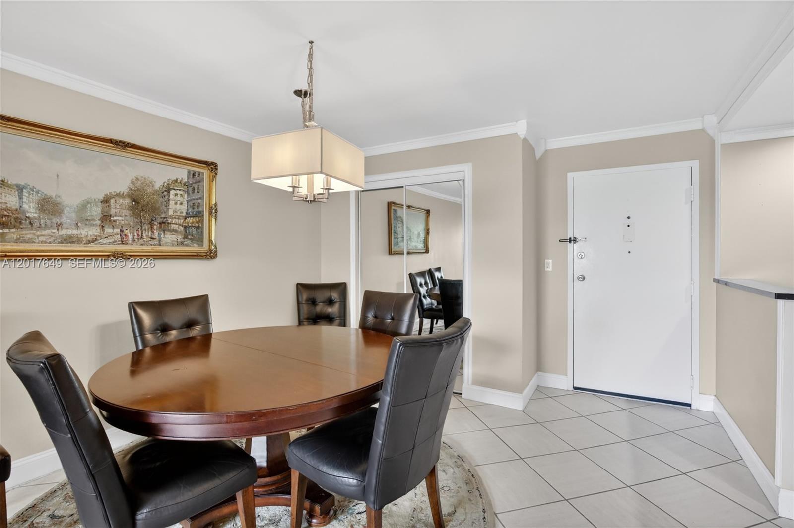 A dining room features a round wooden table, leather chairs, a chandelier, and tiled floors — 6600 Cypress Rd # 504, Plantation FL 33317, PLANTATION, FL