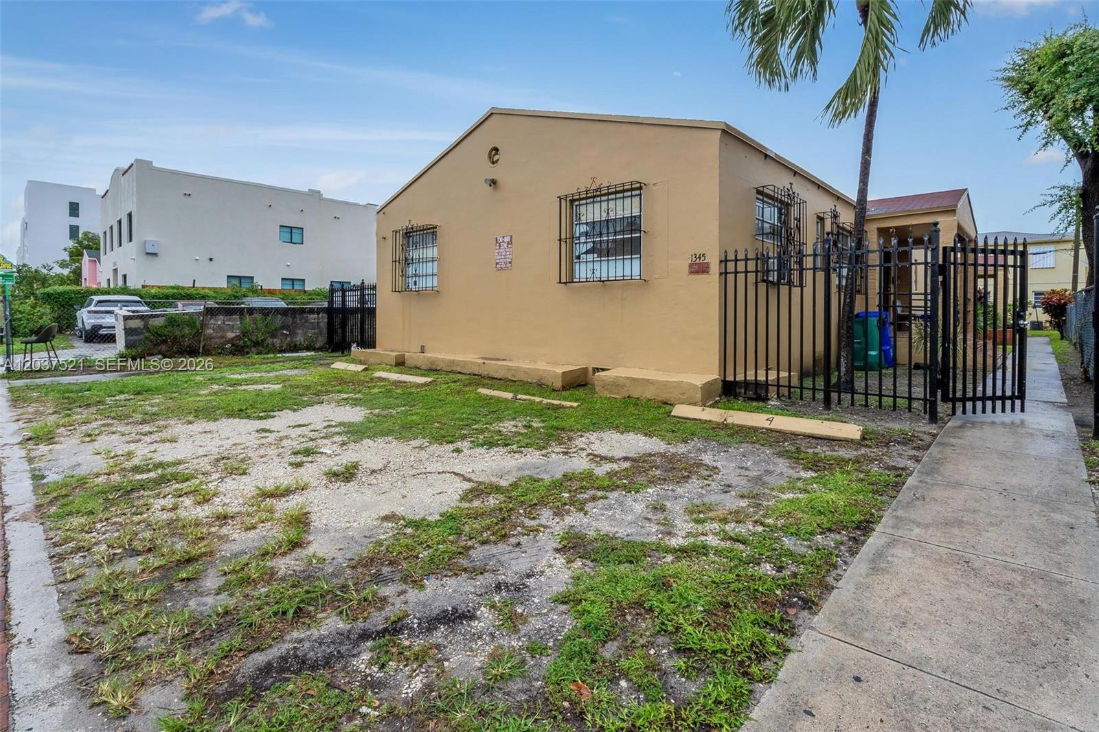 A tan, single-story house with a gravel parking area and a black metal fence — 1345 SW 7th ST, Miami FL 33135, MIAMI, FL