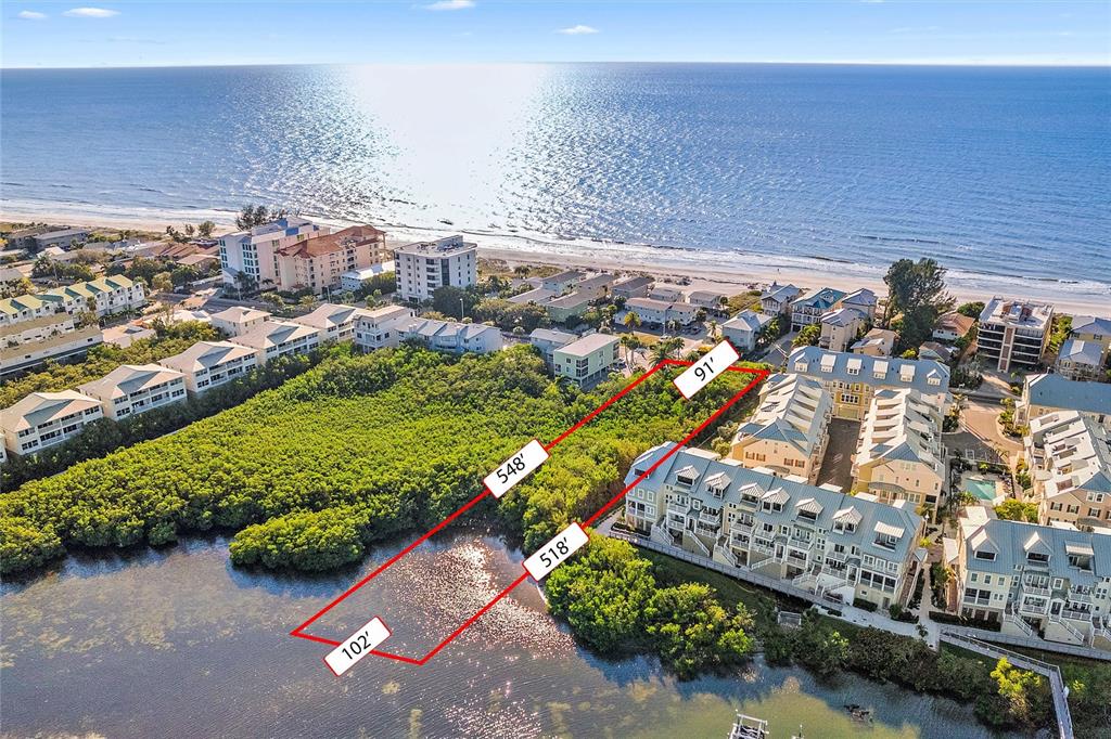 An aerial view shows a vacant, rectangular waterfront lot outlined in red near the ocean — 19901 GULF BLVD, INDIAN SHORES, FL