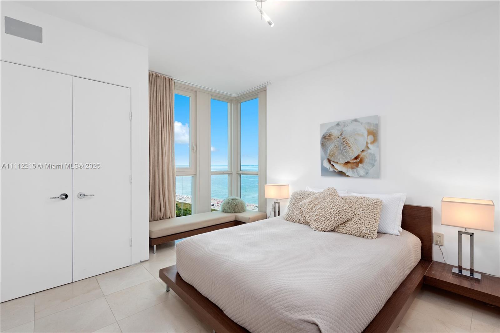 A bedroom features a platform bed, two lamps, and floor-to-ceiling windows overlooking the ocean — 101 20th St # 2401, Miami Beach FL 33139, MIAMI BEACH, FL