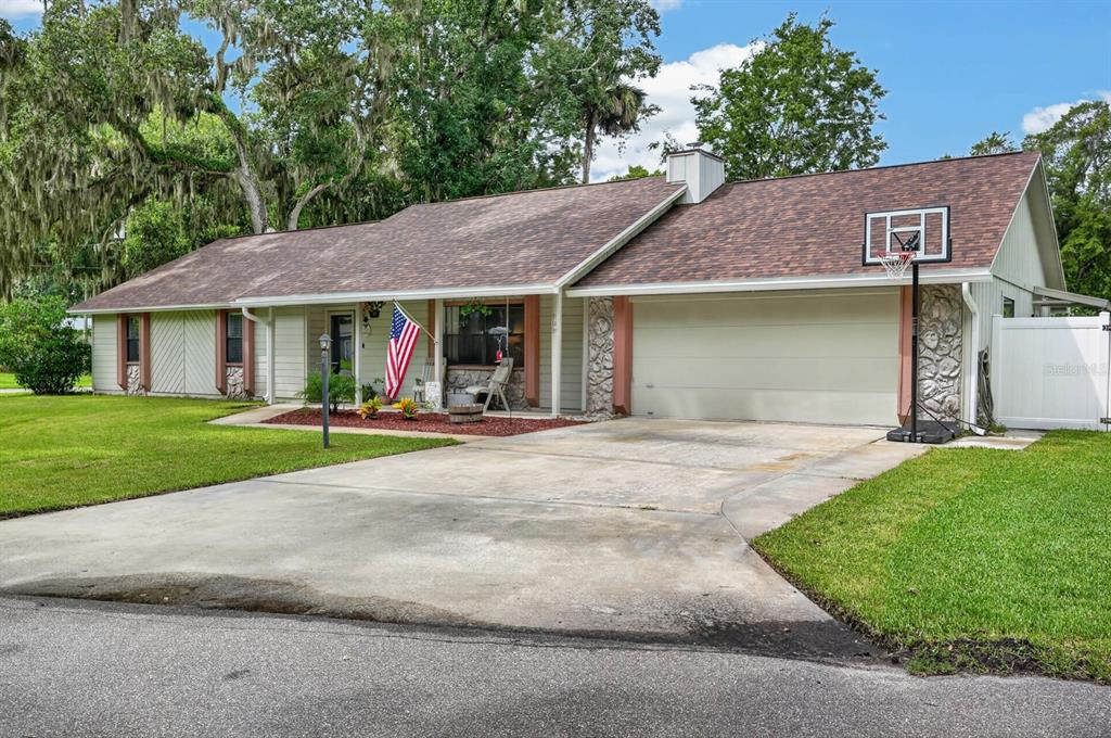 A single-story house with a concrete driveway, a two-car garage, and a basketball hoop — 105 EDDY LANE, PORT ORANGE, FL