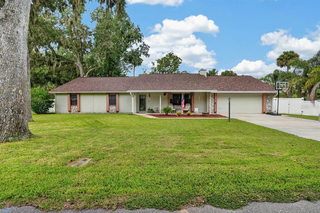 A single-story house with a brown roof, light siding, and a front lawn with trees — 105 EDDY LANE, PORT ORANGE, FL