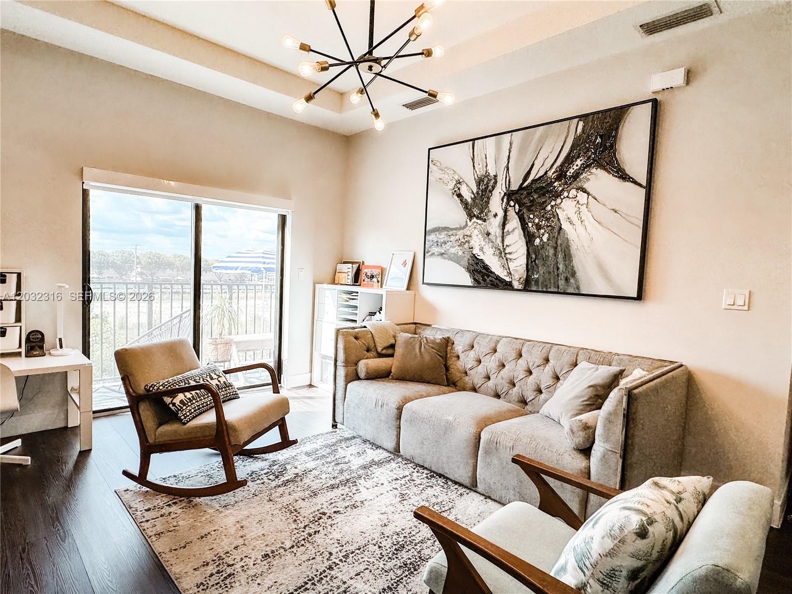 A living room features a tufted sofa, a rocking chair, and a large abstract painting — 10455 NW 82nd St # 32, Doral FL 33178, DORAL, FL