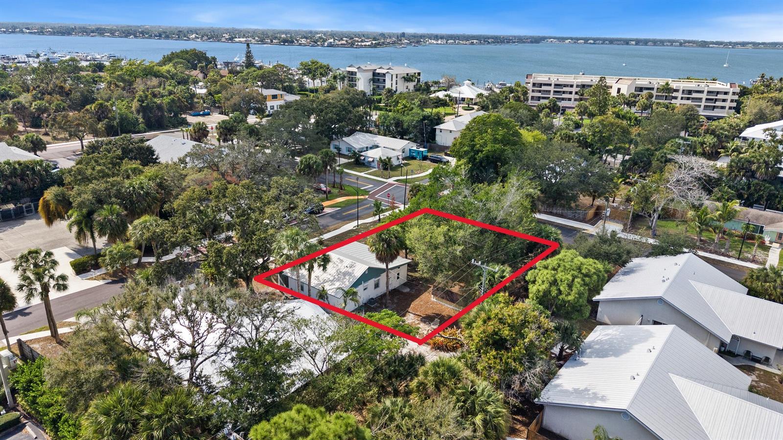 An aerial view shows a single-story house outlined in red surrounded by trees and vegetation — 621 NW Australian Street, Stuart FL 34994, STUART, FL