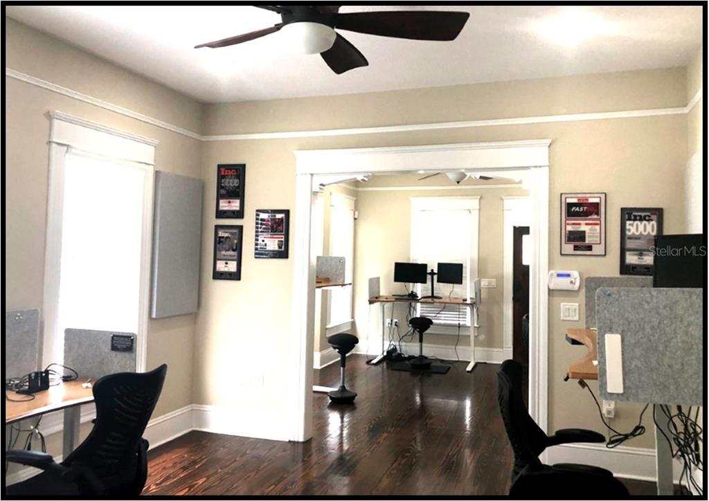 An office space with hardwood floors, multiple standing desks, and framed awards on the walls — 106 W EUCLID AVENUE, TAMPA, FL