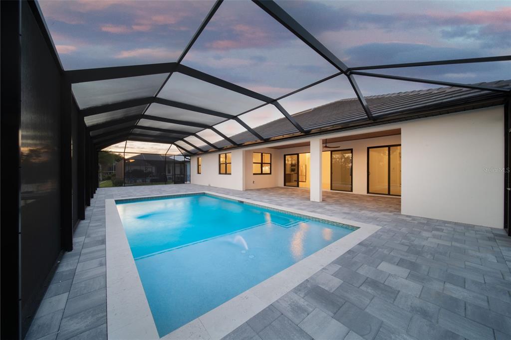 A swimming pool with a fountain sits on a paved patio inside a screened enclosure — 836 SW 36TH TERRACE, CAPE CORAL, FL