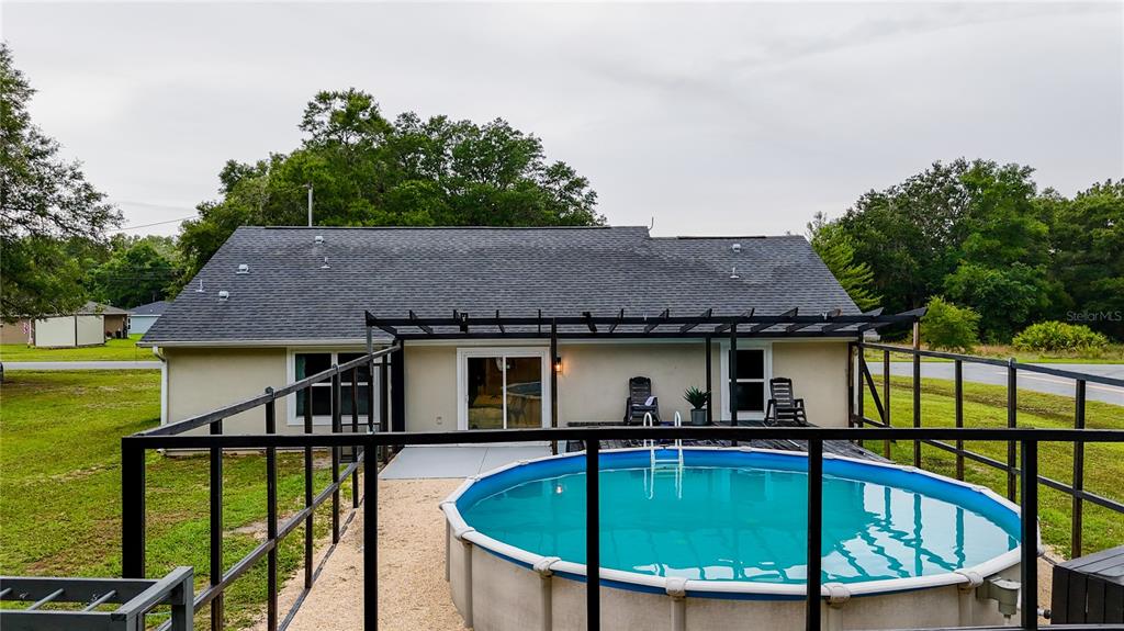 A backyard view shows a house with a gray roof, a patio, and an above-ground pool — 126 LOCUST RADIAL, OCALA, FL