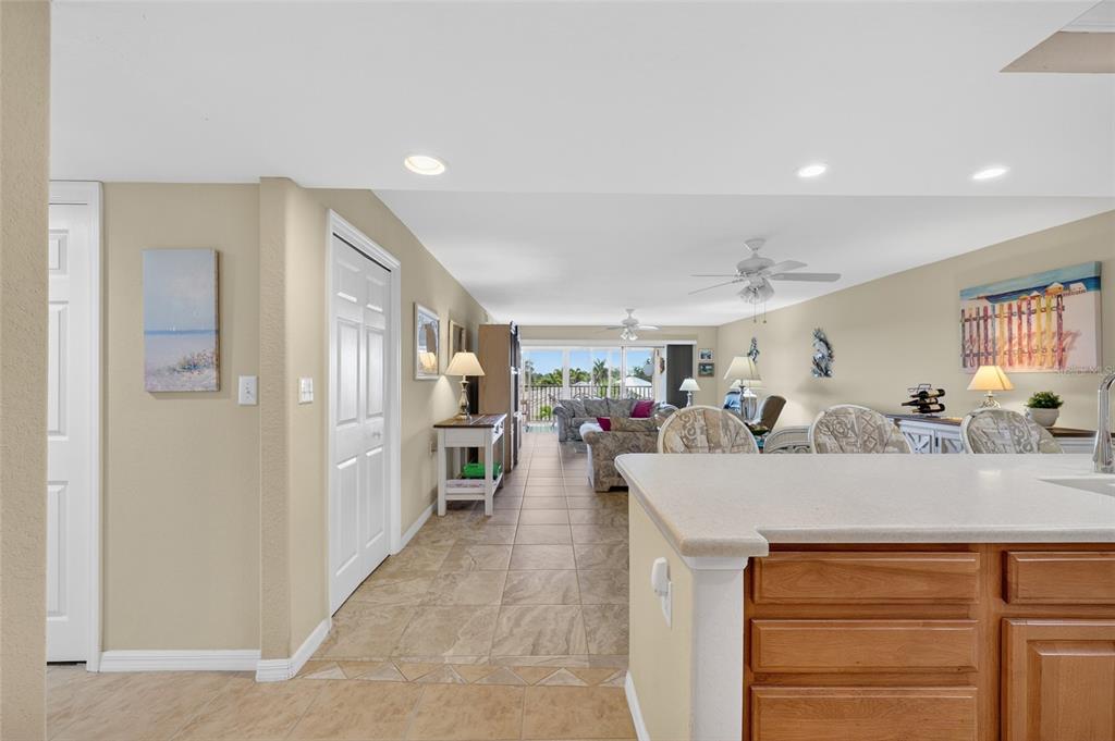 A view from a kitchen looking across a tiled living area toward a balcony — 601 SHREVE STREET UNIT 51C, PUNTA GORDA, FL