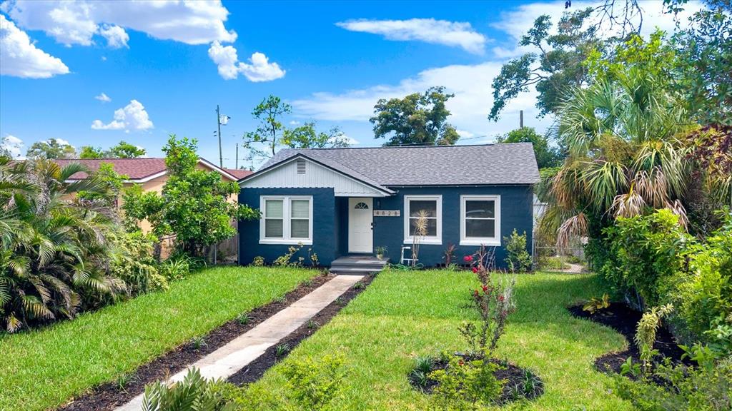 A dark blue, single-story house with a gray shingled roof and a front walkway — 4828 6TH AVENUE S, ST PETERSBURG, FL