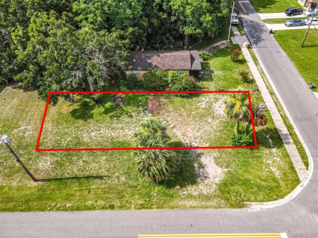 An aerial view shows a rectangular vacant lot outlined in red next to a house — 939 MOTON AVENUE, SANFORD, FL