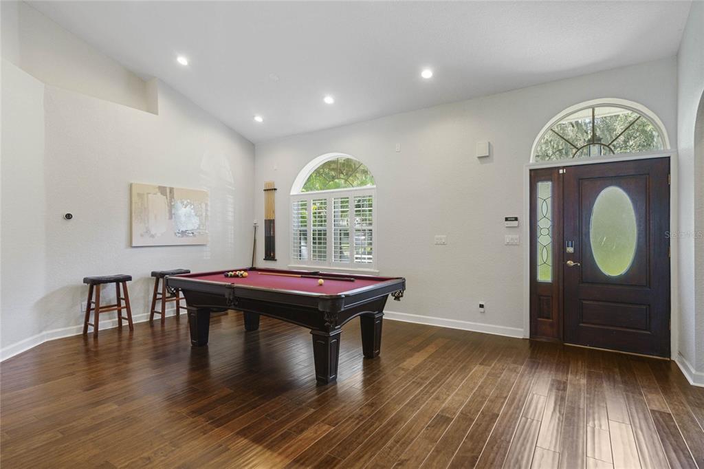 A room with hardwood floors, a pool table, and a front door with a window — 715 MAGNOLIA STREET, WINDERMERE, FL