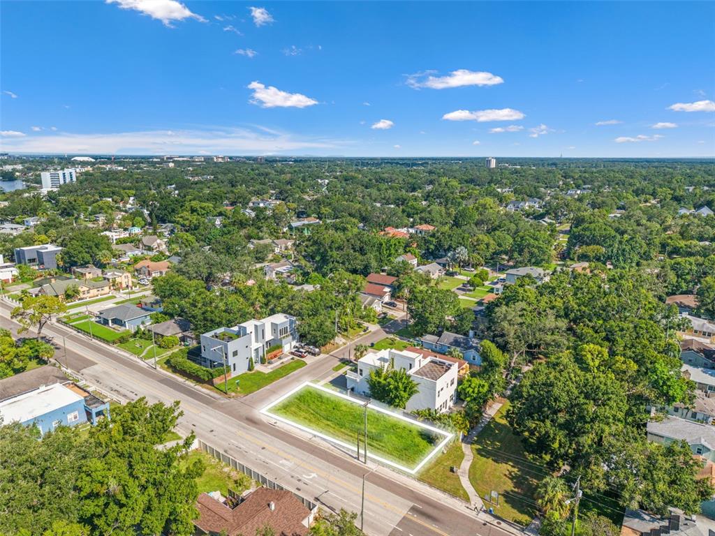 An aerial view shows a vacant rectangular lot situated between two modern houses along a road — 2701 N MYRTLE AVENUE, TAMPA, FL