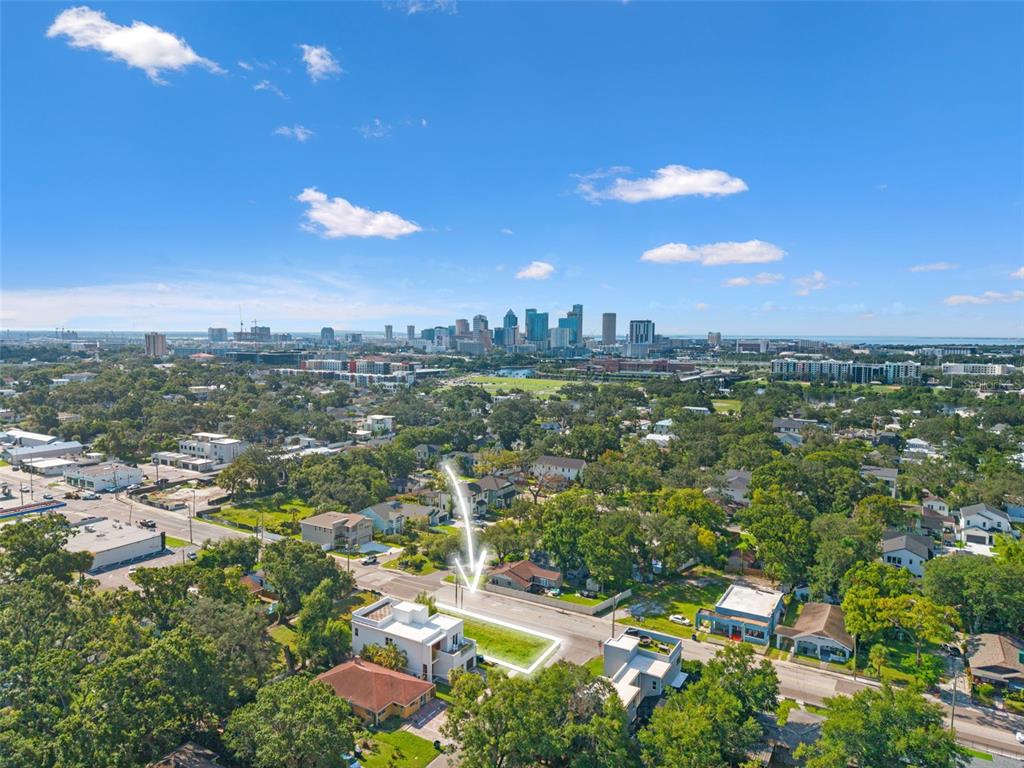An aerial view shows a vacant lot highlighted in a residential neighborhood near a city skyline — 2701 N MYRTLE AVENUE, TAMPA, FL